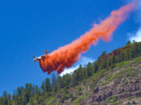 An air tanker drops fire-retardant slurry