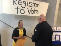 Weld County Clerk and Recorder Carly Koppes talks to a man about voter registration.