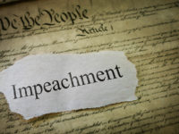 Impeachment news headline on a copy of the United States Constitution