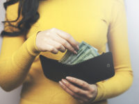woman  taking  dollars money from black wallet