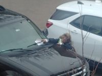 A employee of the City of Greeley places a parking ticket on a vehicle parked outside a downtown Greeley business.